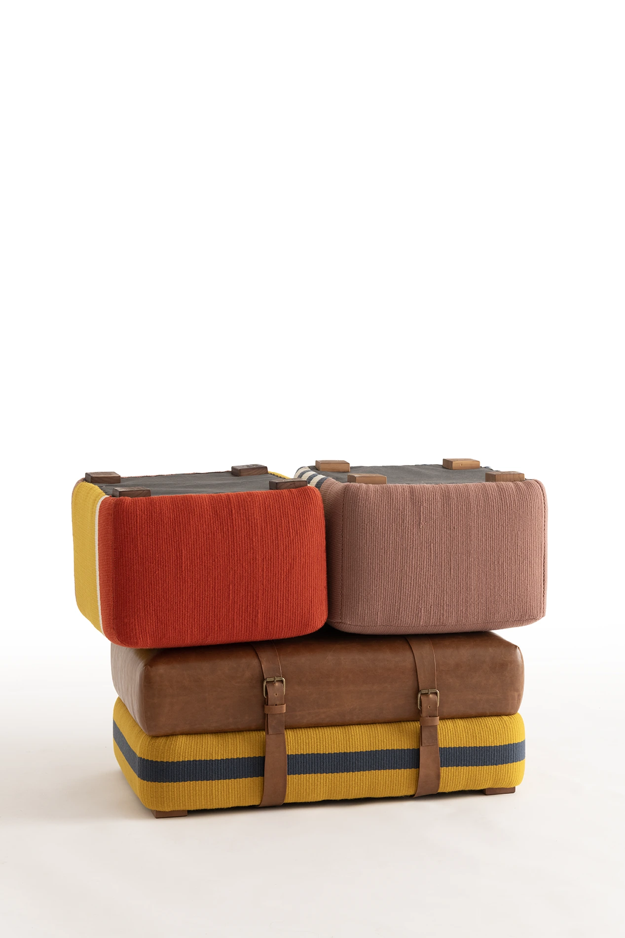 Poufs textiles apilados en colores rojo, amarillo, rosado y gris, Colección Color